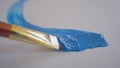 CLOSE UP: Detailed shot of a brush drawing a curved line with light blue paint. Royalty Free Stock Photo