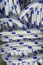 Close up and detailed view of a coiled plastic rope with white and blue fibers Royalty Free Stock Photo