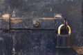 Close up detailed view of an old black door with an iron padlock Royalty Free Stock Photo