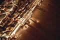 Close up and detailed view of a shiny keys of a golden saxophone lying on leather sofa. Musical instruments. Royalty Free Stock Photo