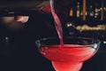 Close up details of barman pouring vodka cosmopolitan cocktail in martini glass. Royalty Free Stock Photo