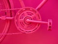 Close up details of a bicycle painted in pink color.