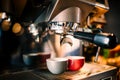 details of brewing machinery pouring and preparing espresso in two cups. Cafe shop details