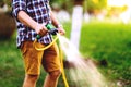 Close up details of gardener using hosepipe watering the lawn, grass and plants Royalty Free Stock Photo