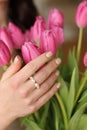 Close-up of the details of the girl's beautified hands with jewelry holding pink flowers Royalty Free Stock Photo