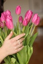 Close-up of the details of the girl's beautified hands with jewelry holding pink flowers Royalty Free Stock Photo