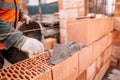 Close up details of industrial bricklayer installing bricks on industrial building
