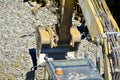 Close up details of an industrial excavator working on a construction site. Excavator bucket levels gravel on the roadway. Men at Royalty Free Stock Photo