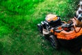 Details of industrial lawnmower with caucasian man behind it