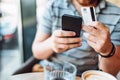 Close up details of man using smartphone and credit card for online shopping Royalty Free Stock Photo