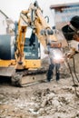 details of professional welder working on broken excavator, repairing and working