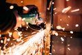 Close up details of sparks, industrial worker using angle grinder and cutting steel