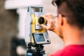 Details of survey engineer using and working with total station theodolite at landscaping project Royalty Free Stock Photo