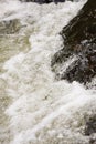 Close up details of waterfall stream white bubbles small countryside river