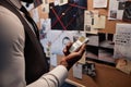 Close up of detective holding voice recorder standing by evidence board