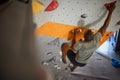 Close Up Of Determined Man Tackling Climbing Wall At Indoor Activity Centre Royalty Free Stock Photo