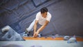 Close Up Of Determined Man Tackling Climbing Wall At Indoor Activity Centre Royalty Free Stock Photo