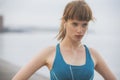 A close up of a determined woman athlete running by the seaside