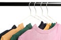 Different colorful T-shirts on hangers on white background. Royalty Free Stock Photo