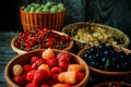 Close up different kind of baskets with fruits on vintage wood background. Red, black and white currant, green and red gooseberry Royalty Free Stock Photo