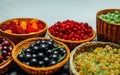 Close up different kind of baskets with fruits on white background. Red, black and white currant, green and red gooseberry, Royalty Free Stock Photo