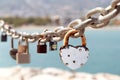 Close up of different old rusty love locks on chain against the sea. Selective focus. Blurred background Royalty Free Stock Photo