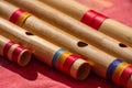 India, Close up of different sizes Hindu bamboo flute called Bansuri on a red table.