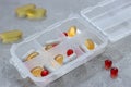Close up of different type daily pills in the pill organizer on the grey marble. Royalty Free Stock Photo