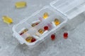 Close up of different type daily pills in the pill organizer on the grey marble. Royalty Free Stock Photo