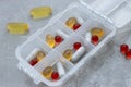 Close up of different type daily pills in the pill organizer on the grey marble. Royalty Free Stock Photo