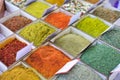Close-up of different types of colored oriental spices and seasonings on market in square forms with price tags Royalty Free Stock Photo