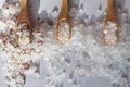 Close-up of different types of salt scattered side by side on a light-colored background. Small bamboo spoons lie on top of the Royalty Free Stock Photo