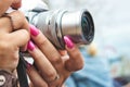 Close-up of a digital camera being used by a woman with painted fingernails