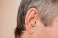 Close-up Digital modern hearing aid in the ear of aged old man Royalty Free Stock Photo