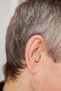 Close-up Digital modern hearing aid in the ear of aged old man Royalty Free Stock Photo