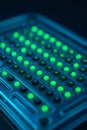 A close-up of a digital PCR droplet reader panel with glowing green samples Royalty Free Stock Photo