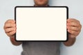 Close up of a digital tablet in man's hands. An upper half shot of a man holding a tablet with white screen in hands. Person on