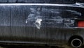 Close-up of a dirty car bumper with visible damage including deep scratches, scrapes, and a peeled area revealing the underlying Royalty Free Stock Photo