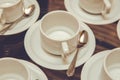 Close up dirty coffee cup and spoon setting on white saucer and wooden table after drinking in the morning in vintage style. cup Royalty Free Stock Photo