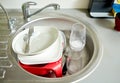 Close up of dirty dishes washing in kitchen sink Royalty Free Stock Photo