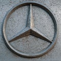 Close up of dirty dusty Mercedes Benz metal logotype on the silver car background