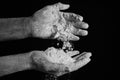 Close up dirty cook hands with dough, flour. Against dark background Royalty Free Stock Photo