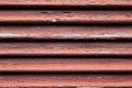 Close up of a dirty old red wooden window shutter with weathered and cracked paint Royalty Free Stock Photo