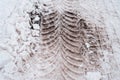 Close-up of dirty snow in winter in the city. Traces of the wheels of the car`s tread on the snow.