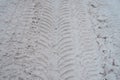 Close-up of dirty snow in winter in the city. Traces of the wheels of the car`s tread on the snow.