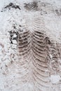 Close-up of dirty snow in winter in the city. Traces of the wheels of the car`s tread on the snow.