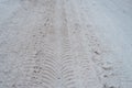 Close-up of dirty snow in winter in the city. Traces of the wheels of the car`s tread on the snow.