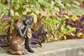 Close up of discarded miniature statue of Buddha kept in a backyard / garden made of black clay