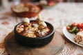 Close-up dish with mushrooms and white sauce in bowl on wooden stand. Traditional Turkish food.