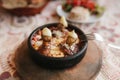 Close-up dish with mushrooms and white sauce in bowl on wooden stand. Traditional Turkish food.